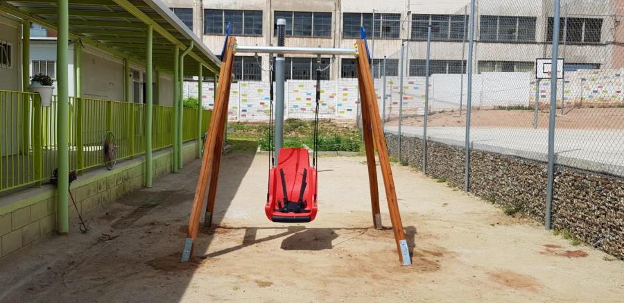 Cadireta de gronxador inclusiva amb cordes i arnès a la estructura del gronxador en una escola d'educació especial de manresa