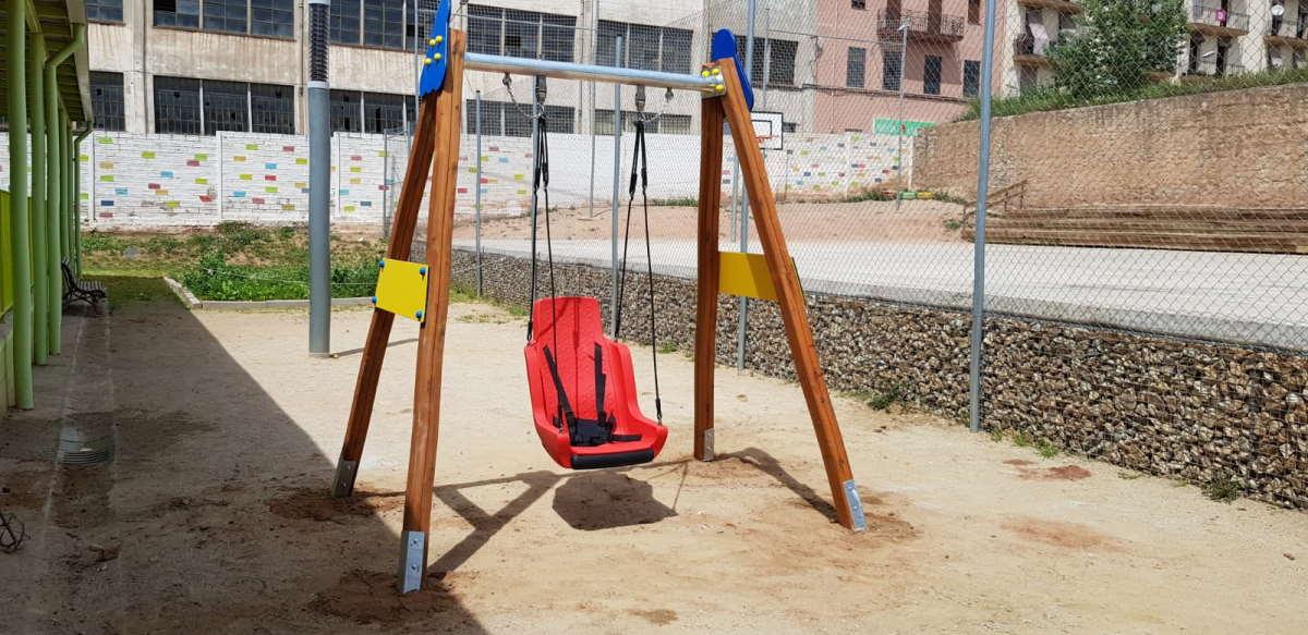 Cadireta de gronxador inclusiva amb cordes i arnès a la estructura del gronxador en una escola d'educació especial de manresa